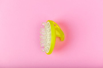 Massage brush on a pink background. Gel brush green. view from above. different angles. Massage brush. Anti-cellulite massage brush. On a pink background. Accessories for massage.
