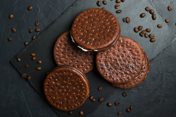 Top view of chocolate biscuits, coffee beans on the black table. Coffee and chocolate taste