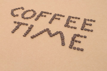 coffee time design spelled with arabica coffee beans on sandy background