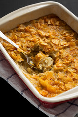 Home-baked Funeral Potatoes Casserole in a dish over black surface, low angle view. Close-up.