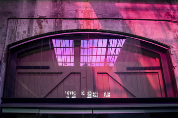 Purple light reflecting on the wall and a big door