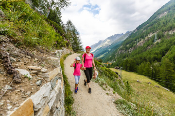 Fototapeta na wymiar Family Walking Hiking Trail In Mountains In Summer