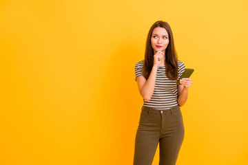 Portrait of cunning cute girl famous blogger want type post think thoughts look copy space use smartphone touch chin hand wear white green outfit isolated over shine color background