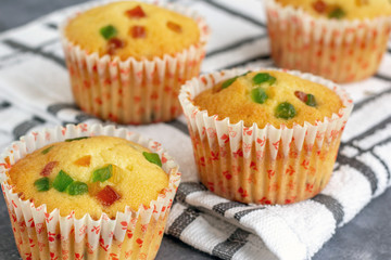 Freshly Baked Tutti Frutti Holiday Muffins on White Kitchen Towel CLose Up Photo.