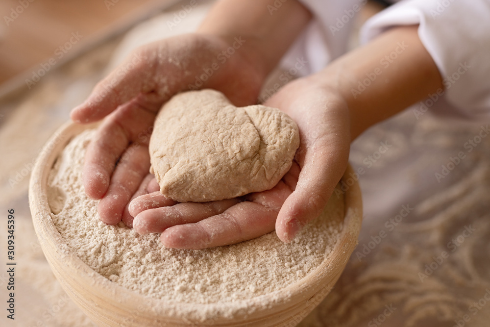 Wall mural little baker showing heart from dough