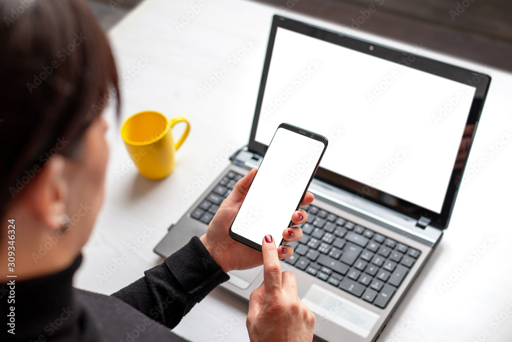 Poster phone and laptop mockup. woman holding smart phone with isolated screen over the laptop with isolate