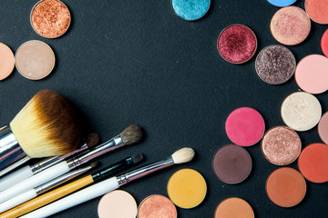 Make-up colorful eyeshadow palettes isolated on black background. View from above. Brushes kit make...