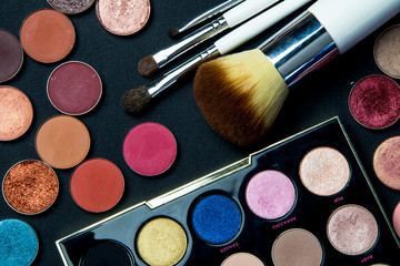Make-up colorful eyeshadow palettes isolated on black background. View from above. Brushes kit make...