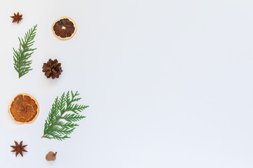 Fir twigs and star anise, tree cone with dry citrus on a white background, Christmas holiday background, flat lay, copy space