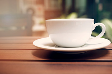 Coffee cup on wood table in garden.