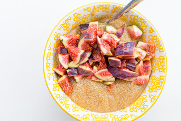 Gluten free amaranth porridge for breakfast with figs in a yellow bowl top view