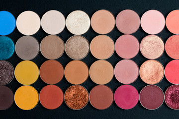 Make-up colorful eye shadow palettes isolated on black background.