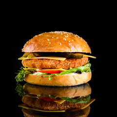 homemade cheeseburger on a black background with reflection