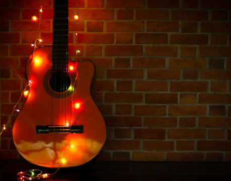 Classical guitar with glowing Christmas string light