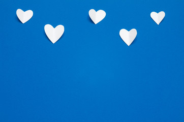 White paper hearts at blue backdrop, top view. Color of the year 2020 Classic Blue. - Image