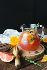 Fresh summer lemonade with grapefruit and rosemary on an old wooden table. Summer concept.