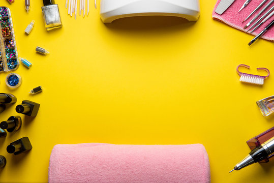 Top view of manicure and pedicure equipment on yellow background