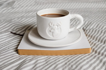 white cup with a pattern of deer. Coffee in a cup. Morning coffee.