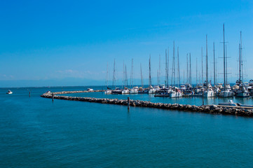 Dock with yachts on a background of blue sea