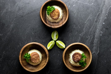 Scallops on Mashed Potatoes with Lime on Slate