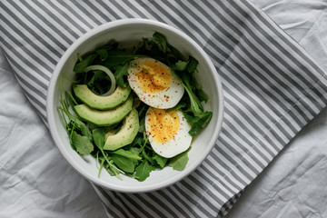 flat lay breakfast. Wholesome food, beautiful serving. Eggs, avocados and greens.