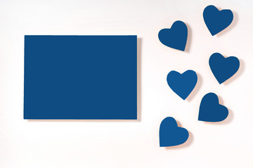 Valentine's day frame composition. Blue hearts blank sheet of paper on white background. Top view, flat lay, copy space