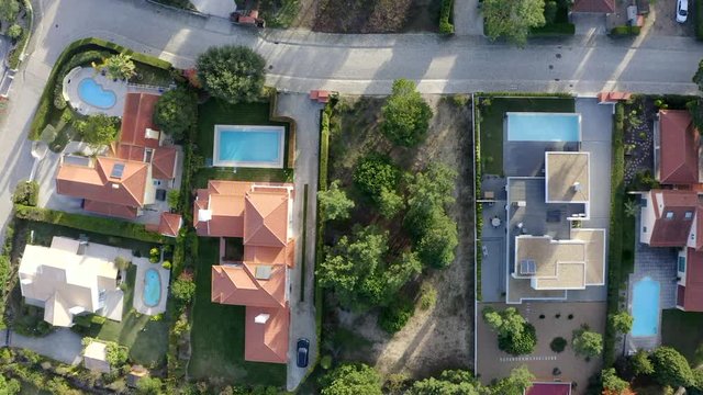 Aerial, top down, drone shot, over houses, buildings, pools and yards, at a neighborhood in Magoito, on a sunny day, in Sintra, Lisbon, Portugal