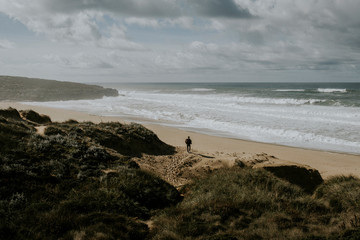 Fototapeta na wymiar Rear view of man walking on beach in Portugal