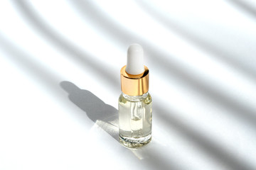 Anti aging serum with collagen and peptides in glass bottle with dropper on white background with...
