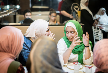 Muslim girls at restaurant having iftar