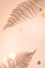 Festive composition. Shiny Christmas decorative floral fern branches, confetti, gold glitters on beige background. Flat lay. Copy space. Stylish christmas concept Minimalism