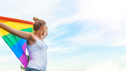 Woman Waving Rainbow Flag at Gay Parade. Young woman with a rainbow flag. Lesbian Girl Holding LGBT Flag. Female is holding the gay rainbow flag