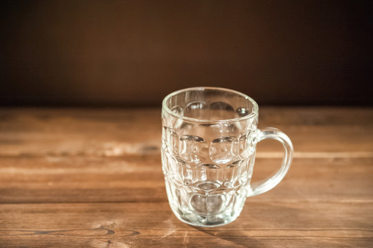 Empty beer glass close-up. Empty beer mug on a dark background and copy space.
