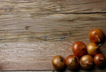 structural background of cracked wooden boards and a group of onions