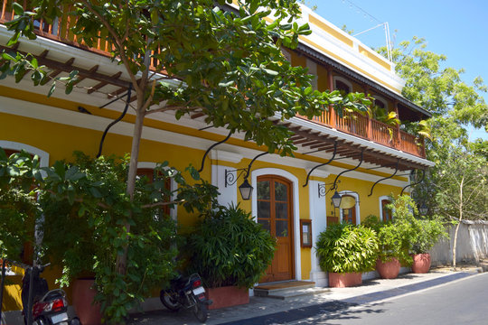 Yellow bright building with lanterns in the french colony in Pondicherry, sunny day and blue sky in Tamil nadu, India.