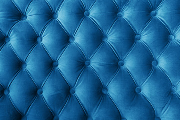 Blue fabric sofa texture with buttons for background and design. Color of the Year 2020 Classic Blue