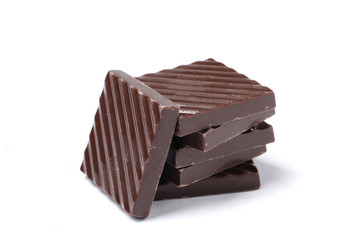 Black chocolate pieces isolated on a white background.