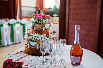 Bottle of champagne with glasses on wedding reception.