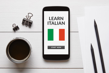 Learn Italian concept on smart phone screen on white wooden desk