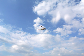 Helicopter aircraft model flying in the blue sky with clouds