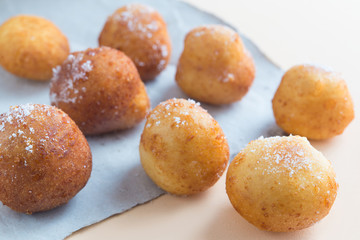 French doughnuts Beignet covered with sugar powder on a brown background