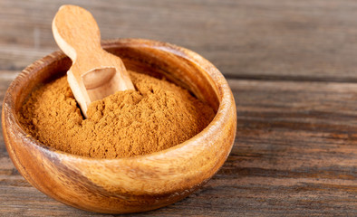 Cinnamon sticks and cinnamon powder on wood