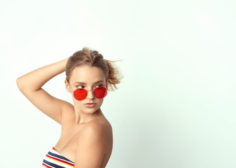 young girl in glasses, beautiful and healthy skin, natural blond hair, empty background, delicate makeup