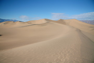 Fototapeta na wymiar Massive sand dunes in Death Valley National Park desert in the winter golden and blue sky