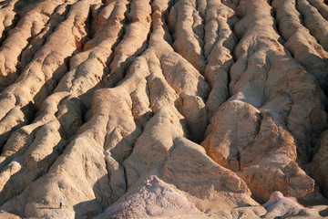 Zabriskie Point lookout over a surreal landscape of undulating ridges of gold, orange, and brown earth in Death Valley National Park and the Panamint Mountains