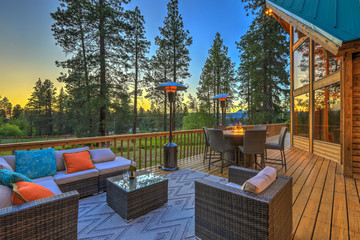 Luxury summer evening mountain home eteriors with cozy porch fire table and new furniture design. - Powered by Adobe