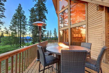 Luxury summer evening mountain home eteriors with cozy porch fire table and new furniture design.