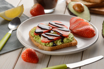 Mashed avocado, strawberry and chocolate syrup