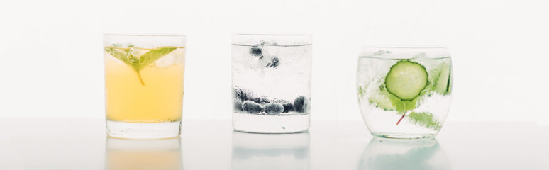 refreshing drinks with blueberries, mint, cucumber and ice isolated on white, panoramic shot