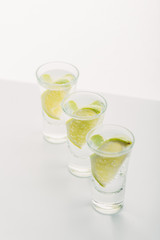 fresh tequila with lime in row isolated on white
